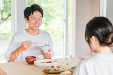 Obraz na płótnie Canvas 家で食事・ご飯を食べる夫婦・男性と女性（新婚・結婚生活・食生活） 