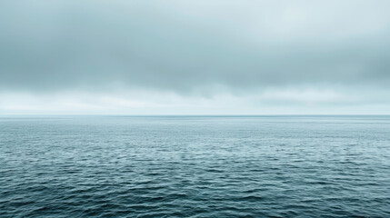 Obraz premium Peaceful ocean expanse under overcast skies in soothing shades