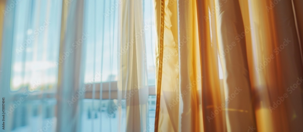 Poster bright sunlight filters in through a window covered by sheer curtains on a clear, sunny day, creatin