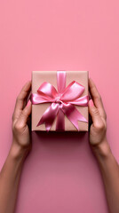 Hands presenting a pink ribboned gift box; symbolizing giving, celebration, and thoughtful gestures.

