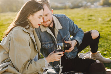 Stylish couple have a picnic with a glasses of wine on a nature