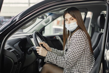 Portrait of female driver in a car wearing face mask