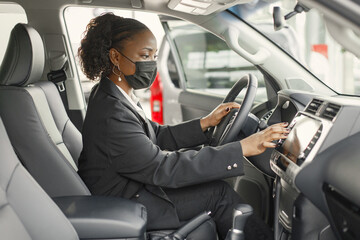 Portrait of black female driver in a car wearing face mask