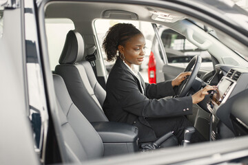 Portrait of black female driver in a car wearing black costume