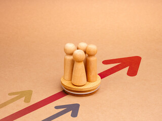 Teamwork, leader, stakeholder, cooperation, wooden figures, team partnership on round wood block with red heading arrows on yellow background. Business strategy with growth success process concept.