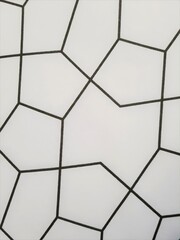 Black and white pattern on a wall featuring repeated geometric shapes creating a visually striking...