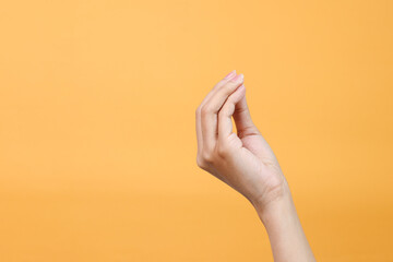 Hand doing Italian gesture with fingers together isolated over yellow background