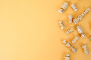 Chess figures isolated over yellow background with copy space. World Chess Day.