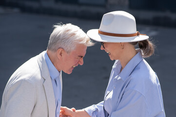 Stylish elderly laughing couple on a walk. Romantic relationships of mature people. 