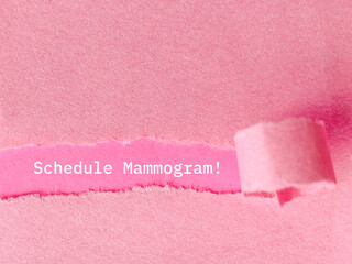 Text of schedule mammogram behind torn paper background. stock photo