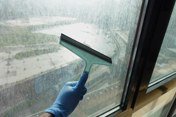 Cleaning windows with a squeegee.
