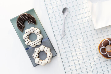 Delicious glazed donuts on white table, flat lay composition