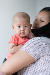 Asian mother holding her infant girl