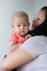 Asian mother holding her infant girl