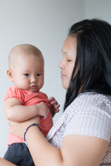 Asian mother holding her infant girl