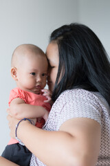 Asian mother holding her infant girl