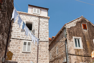 Fototapeta na wymiar Underwear washing hang out to dry between old stone European buildings