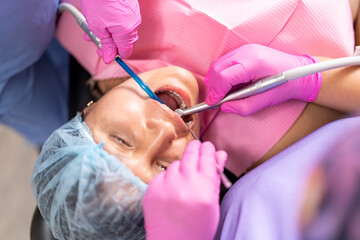 Dentists cleaning the teeth of the patient