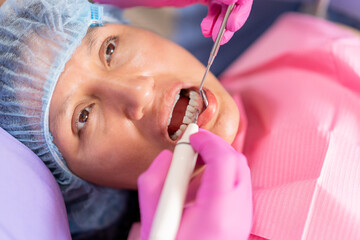 Dentists cleaning a woman's teeth