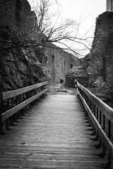 The access bridge to the fortified castle in black and white. The remains of a medieval castle.