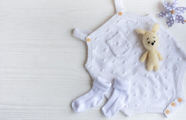 Set of white clothes and accessories for newborn baby.