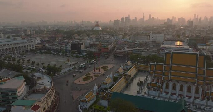 An aerial view of Red Giant Swing and Suthat Thepwararam Temple at sunset scene, The most famous tourist attraction in Bangkok, Thailand.