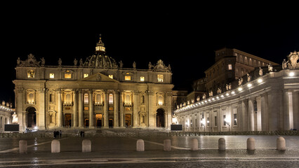 Fototapeta na wymiar Night view of Saint Peter's Square in Vatican City, the papal enclave in Rome, with the Vatican obelisk, an ancient Egyptian obelisk, at the centre and St. Peter's Basilica in the background. 