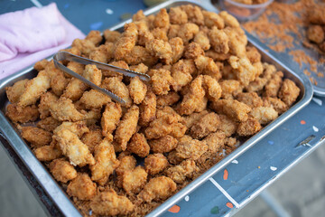 Several pieces of fried chicken nuggets are placed on a tray.