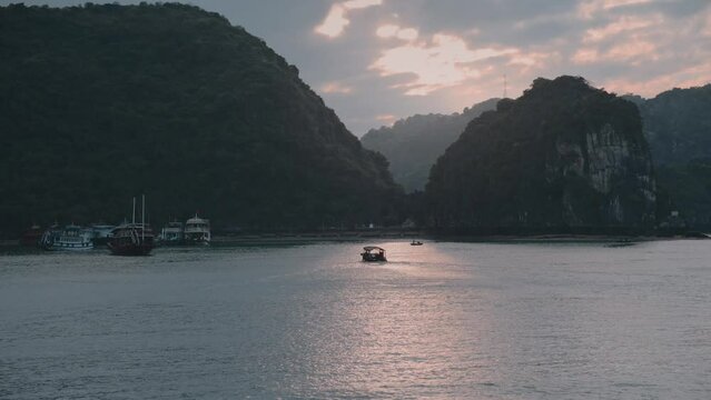 Aerial view of boat sailing on Lan Ha bay during sunset in Vietnam.