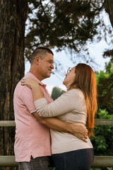 Smiling couple looking at each others face with much love and tenderness. Happy romantic husband and wife outdoors. Mother's day, family and father's day. Nature