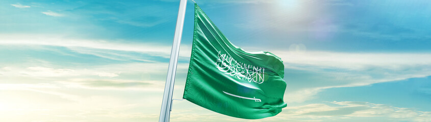 Saudi Arabia flag in waving in beautiful sky with sunlight.