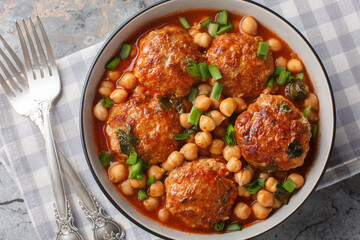 Mediterranean food Lamb meatballs served with chickpeas, tomato and green onions close-up in a bowl...