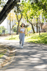 A woman is running on a path in a park