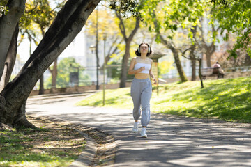 A woman runs on a path in a park
