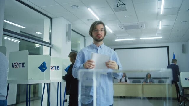Multiethnic European people vote in voting booths at polling station during EU elections. Caucasian male voter puts ballot paper in box. Election Day in the European Union. Civic duty and democracy.