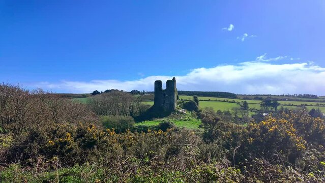 Timelapse of castle in rural Waterford Ireland the ruins of historic Dunhill castle on a windy spring day with clouds drifting over idillic Irish scene