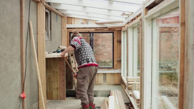 Timelapse - Man Sweeping Inside The Newly Construct Greenhouse With Glass Window.