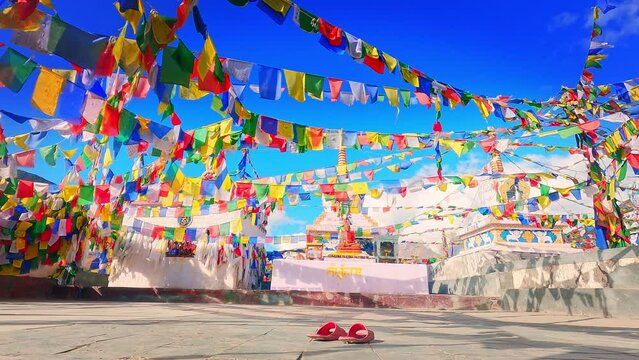 shot of prayer flags waving in the wind in front of the snow covered Himalayan mountains at Kunzum Pass on the way to Kaza from Manali in Himachal Pradesh, India. Prayer flags at Kunzum.