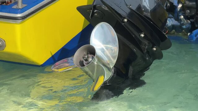 Close up stainless steel motor boat propeller on turquoise sea water background