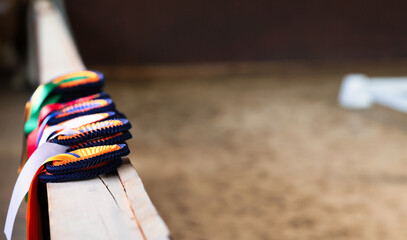 Dressage winner's ribbons lined up on the board, photographed with the aperture wide open. Focus towards the rear.