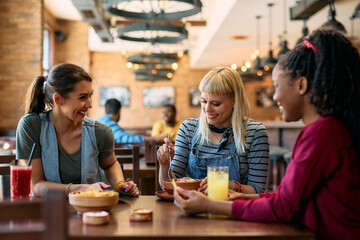 Happy woman enjoying in launch with her female friends in  pub.