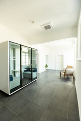 Modern office space captured in natural daylight featuring sleek glass enclosure