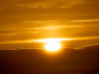 Fototapeta na wymiar Last rays of light sun disappear end day dramatic sunset mountains evening orange sky