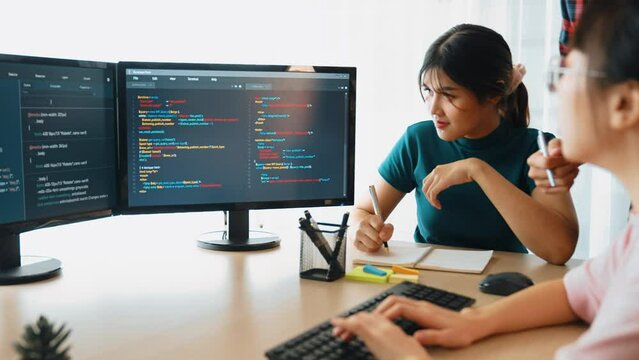 Slow motion back end software developer engineer for computer programming working together on debugging writing computing code, solving complex algorithms display on monitor in office. Burgeoning