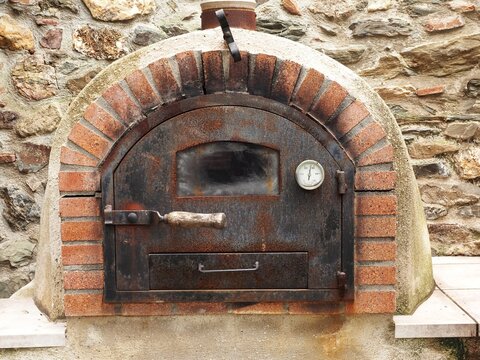 Old, rusty wood-fired oven with a closed door