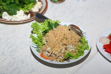 Salad with chicken, nuts and vegetables on a white plate