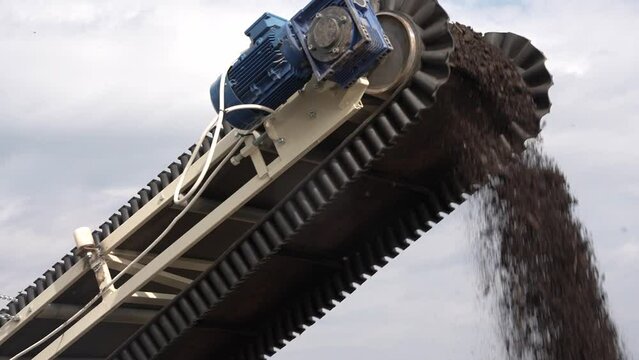 Organic fertilizer conveyor belt for organic vegetables. Heavy machinery working for minerals extraction. Mining extractive industry.