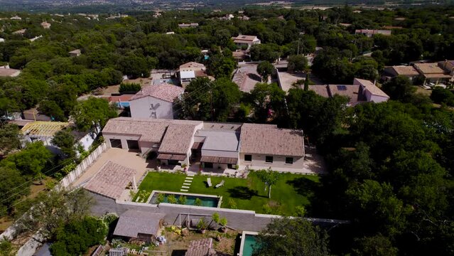 Drone rotation of a magnificent Provençal house with its small garden, deckchairs and Bali stone swimming pool