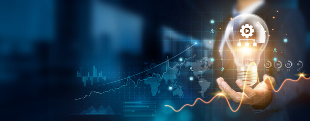 Businessman holding creative light bulb with growth graph and content management icons. Leveraging innovation technology to develop new systems and solutions that enhance successful and profit.