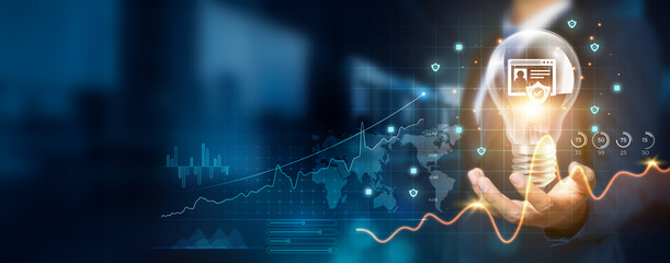 Businessman holding creative light bulb with growth graph and security icons. Implementing...